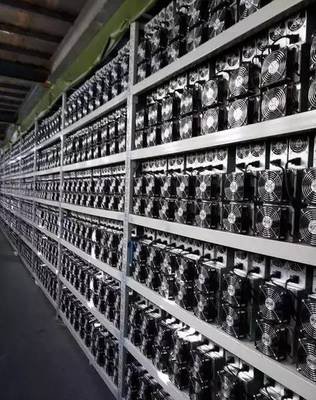 A large mining farm with rows of mining rigs and cooling systems